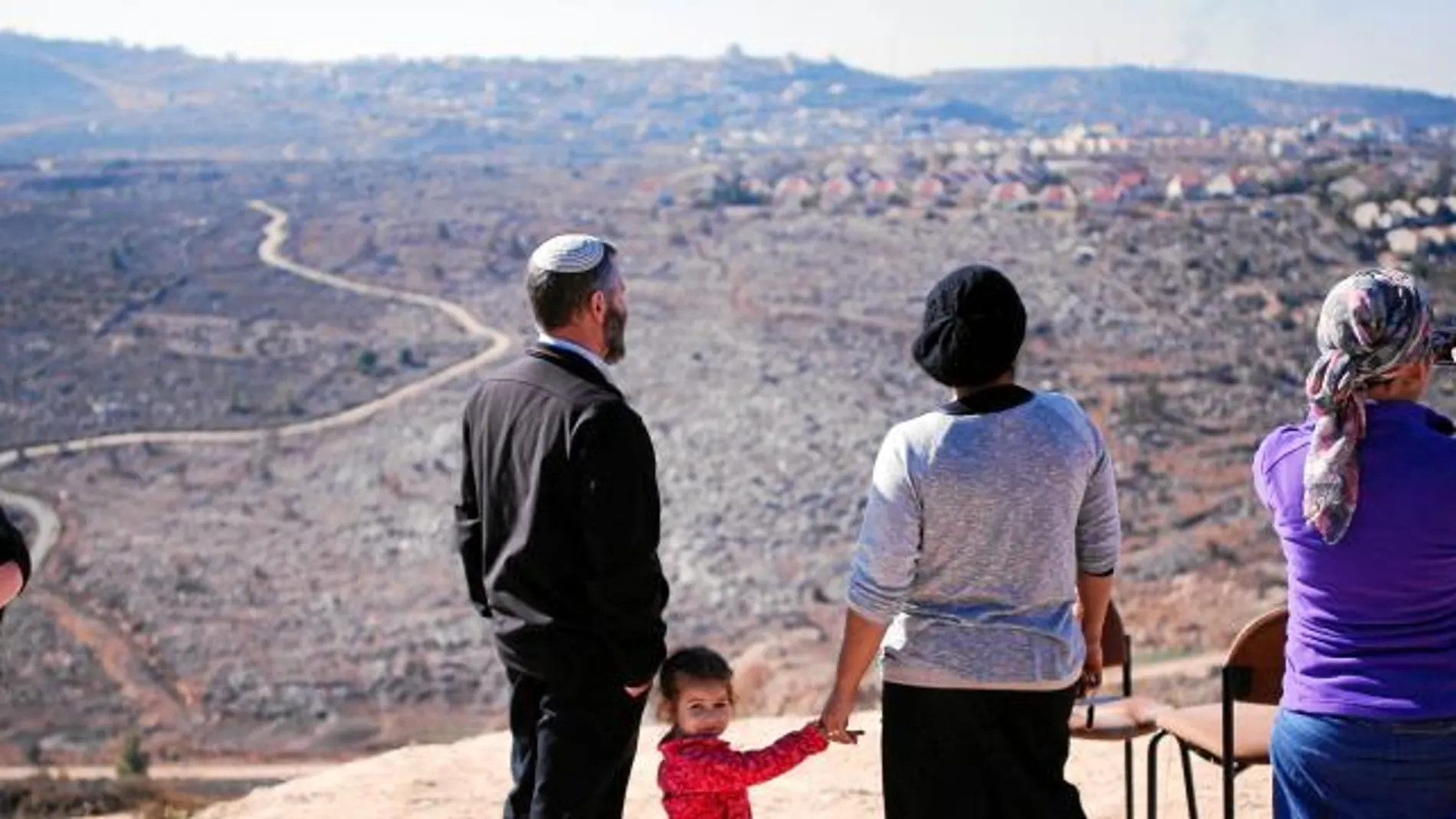 Una familia israelí observa un asentamiento judío desde una colina