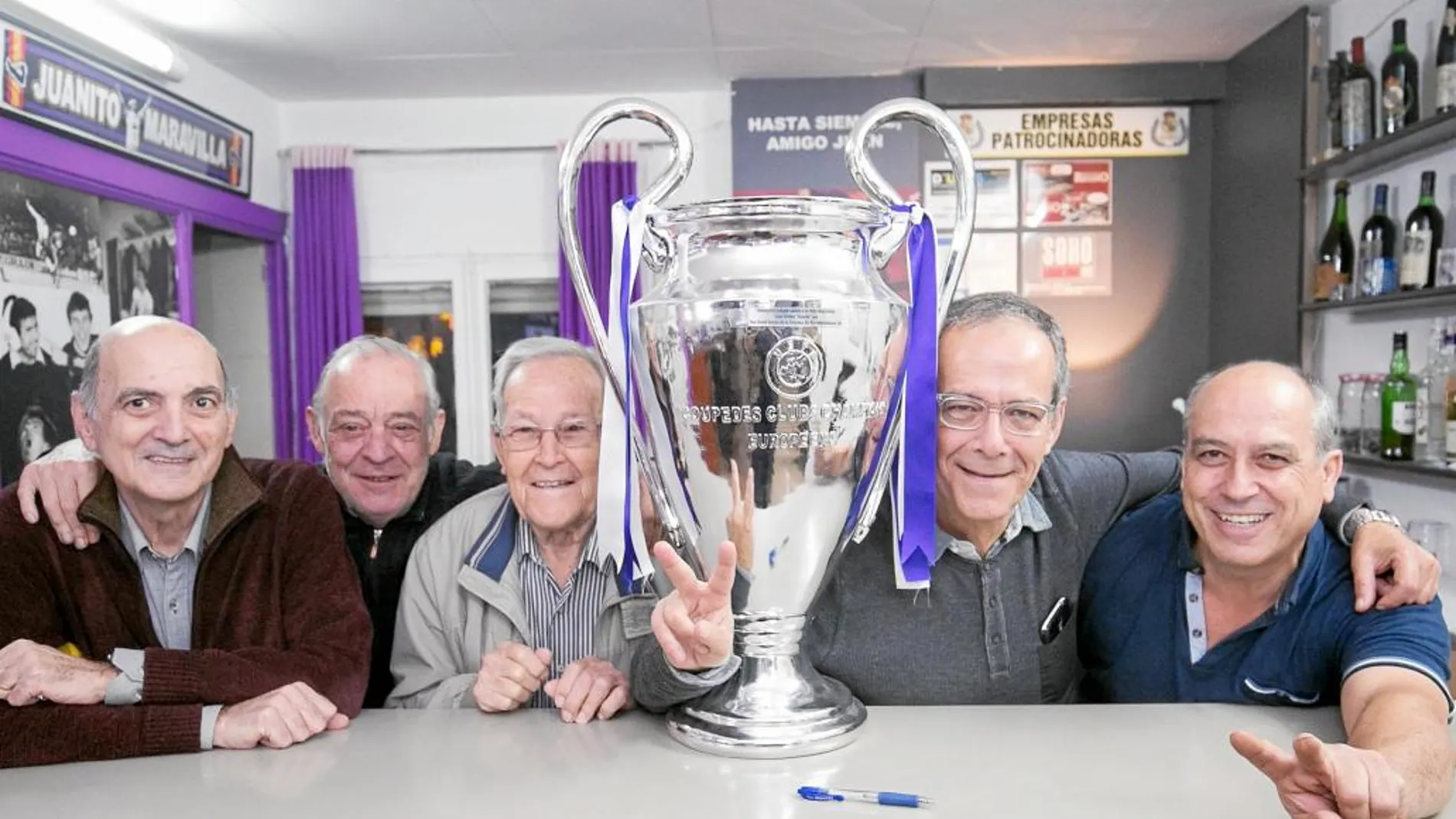 Varios miembros de la Peña Juanito, de Barcelona, posan con una réplica de la Champions