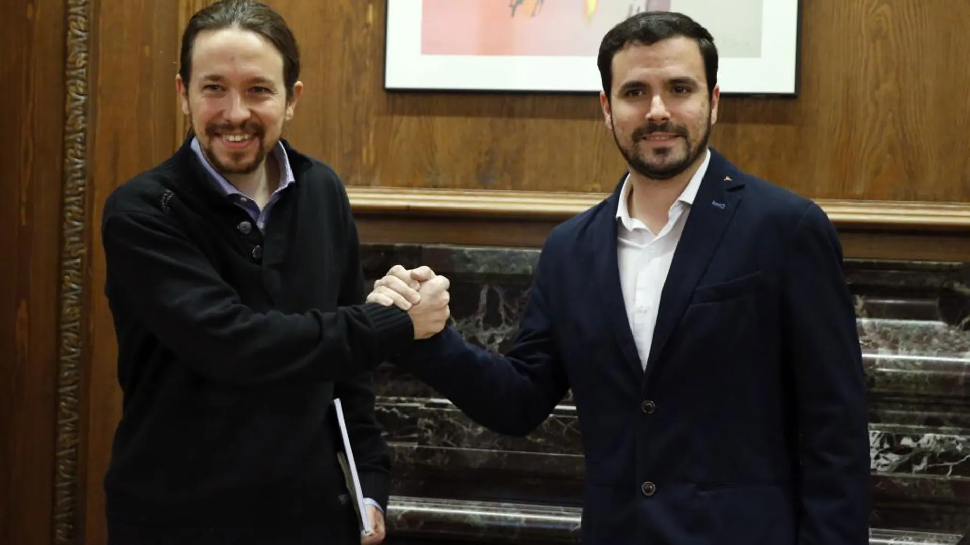 El secretario general de Podemos, Pablo Iglesias (i), y el portavoz de IU-UP, Alberto Garzón, al inicio de la reunión que han mantenido hoy en el Congreso