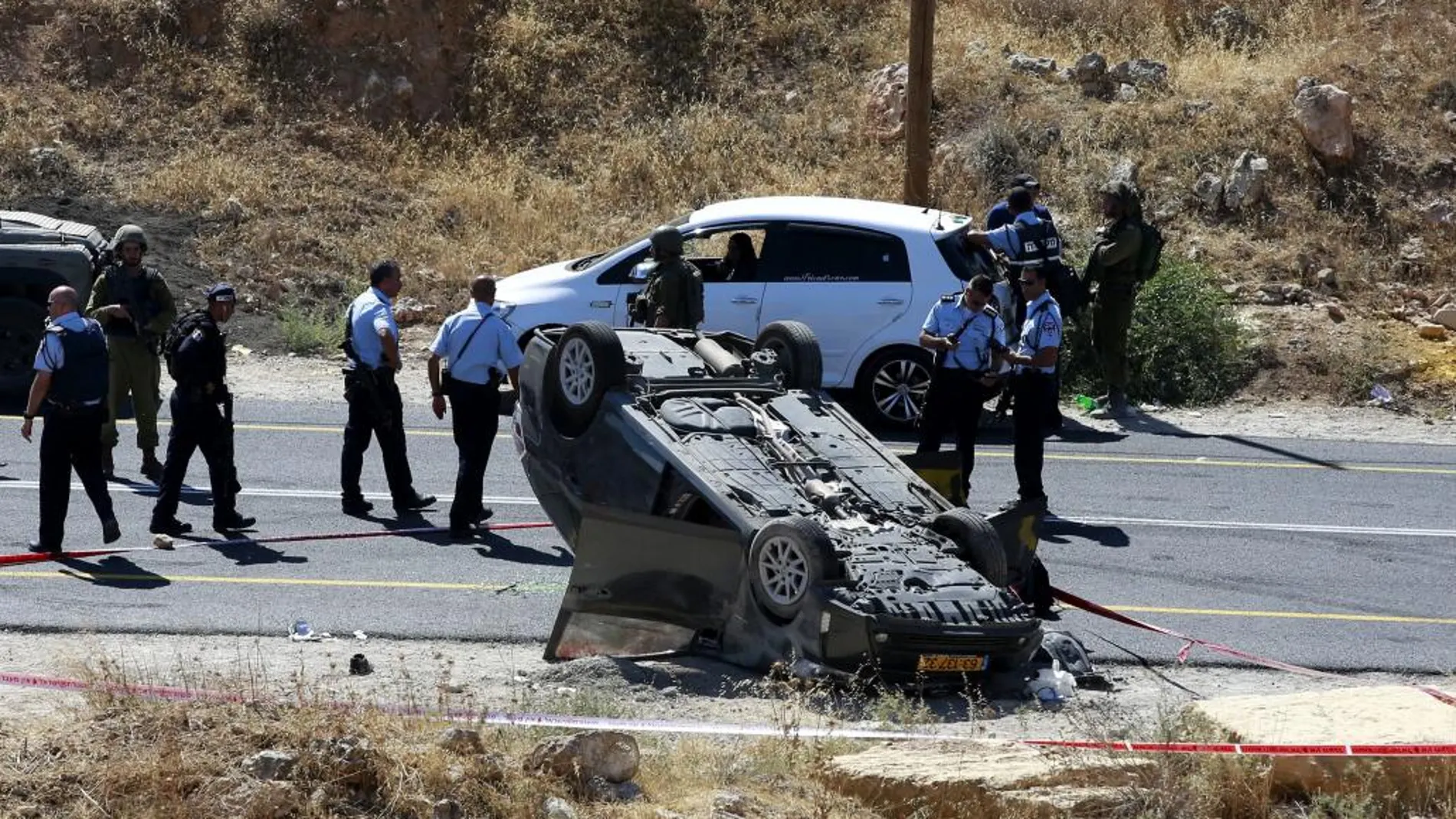 Fuerzas de seguridad israelíes hacen guardia en el lugar del tiroteo en la carretera 60, que cruza Cisjordania de norte a sur, cerca de Dura, Hebrón.