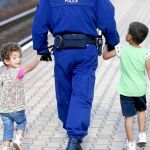 Un policía escolta a dos niños sirios en la estación de Hegyeshalom, en Múnich, ayer