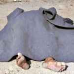 Uno de los cadáveres de los civiles hallados en la ciudad siria de Al Qariatain es cubierto con una manta