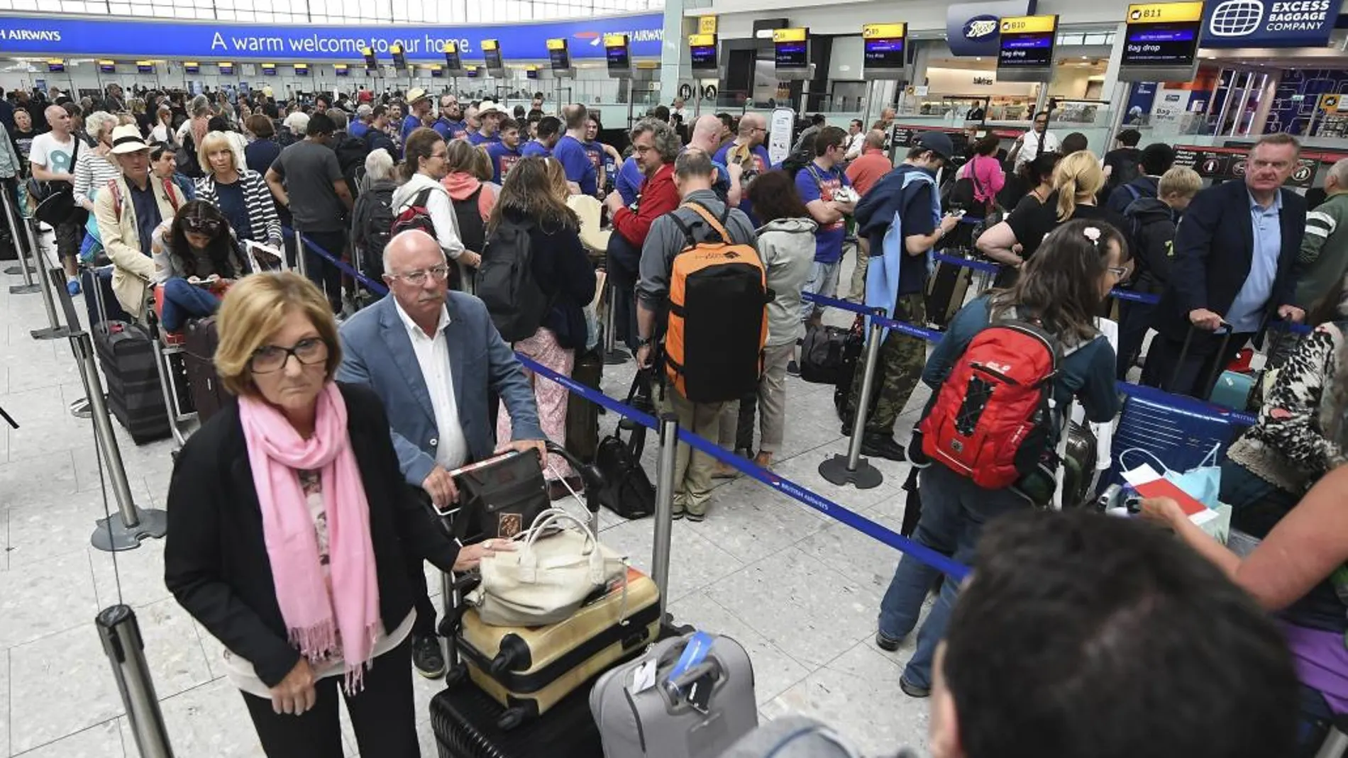 Pasajeros de la compañía británica British Airways esperan en las largas colas en el aeropuerto de Heathrow, en Londres.