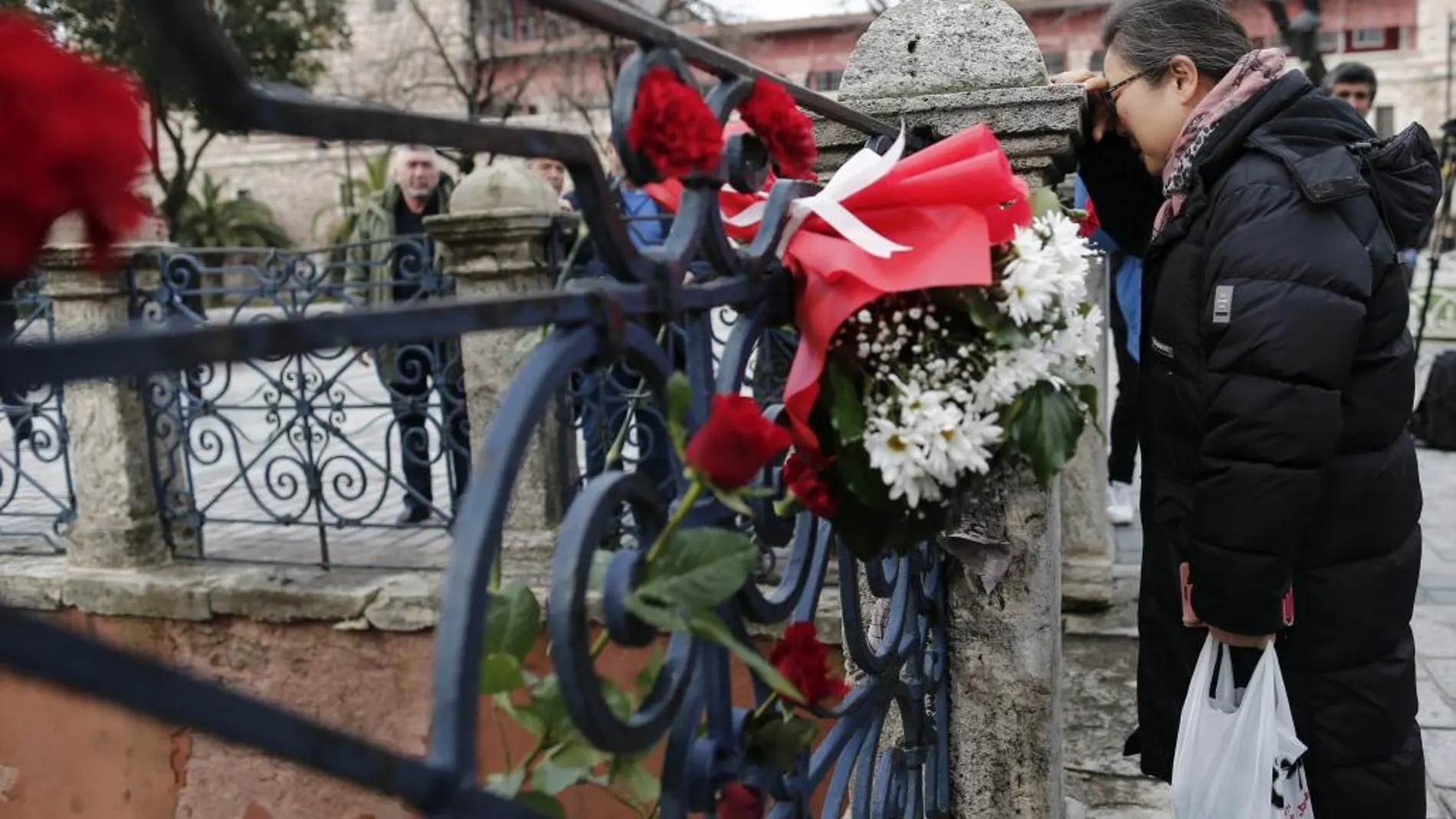 Una turista llora junto a las flores colocadas en homenaje a las víctimas.