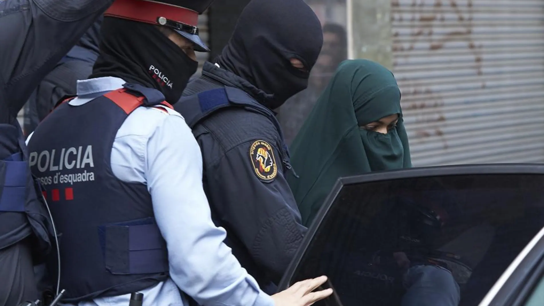 Agentes de los Mossos d'Esquadra salen con la joven detenida de 19 años