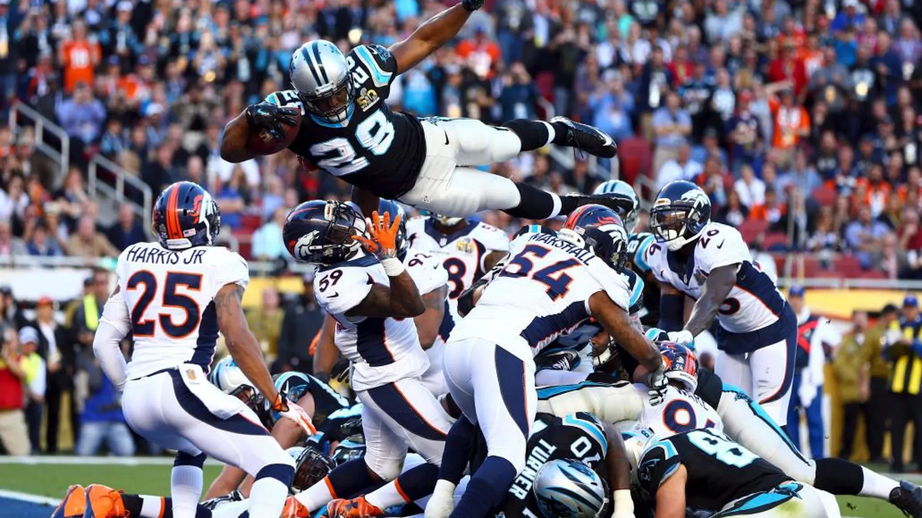 Jonathan Stewart de los Carolina Panthers salta sobre la pila de los defensores para un touchdown