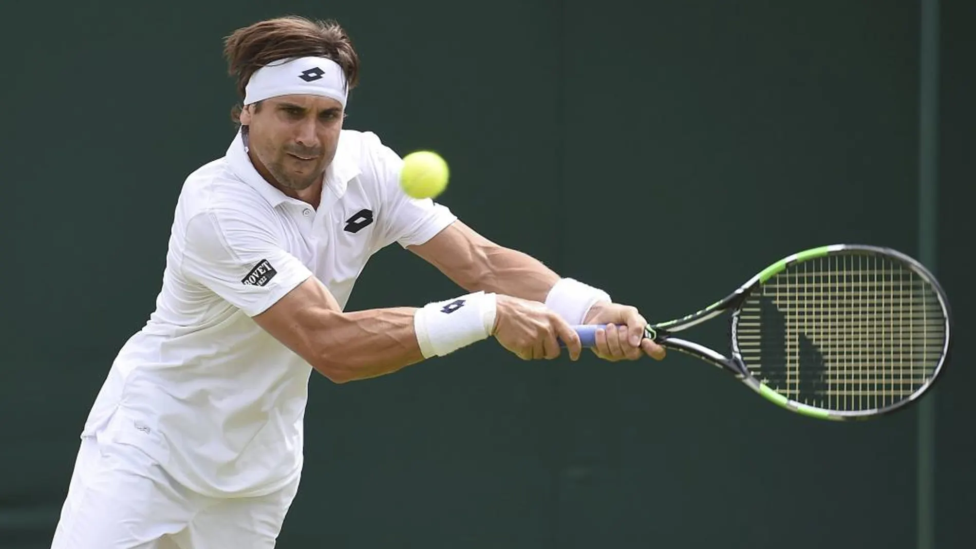El tenista español David Ferrer golpea la bola contra el francés Nicolas Mahut durante su partido de la segunda ronda del torneo de Wimbledon