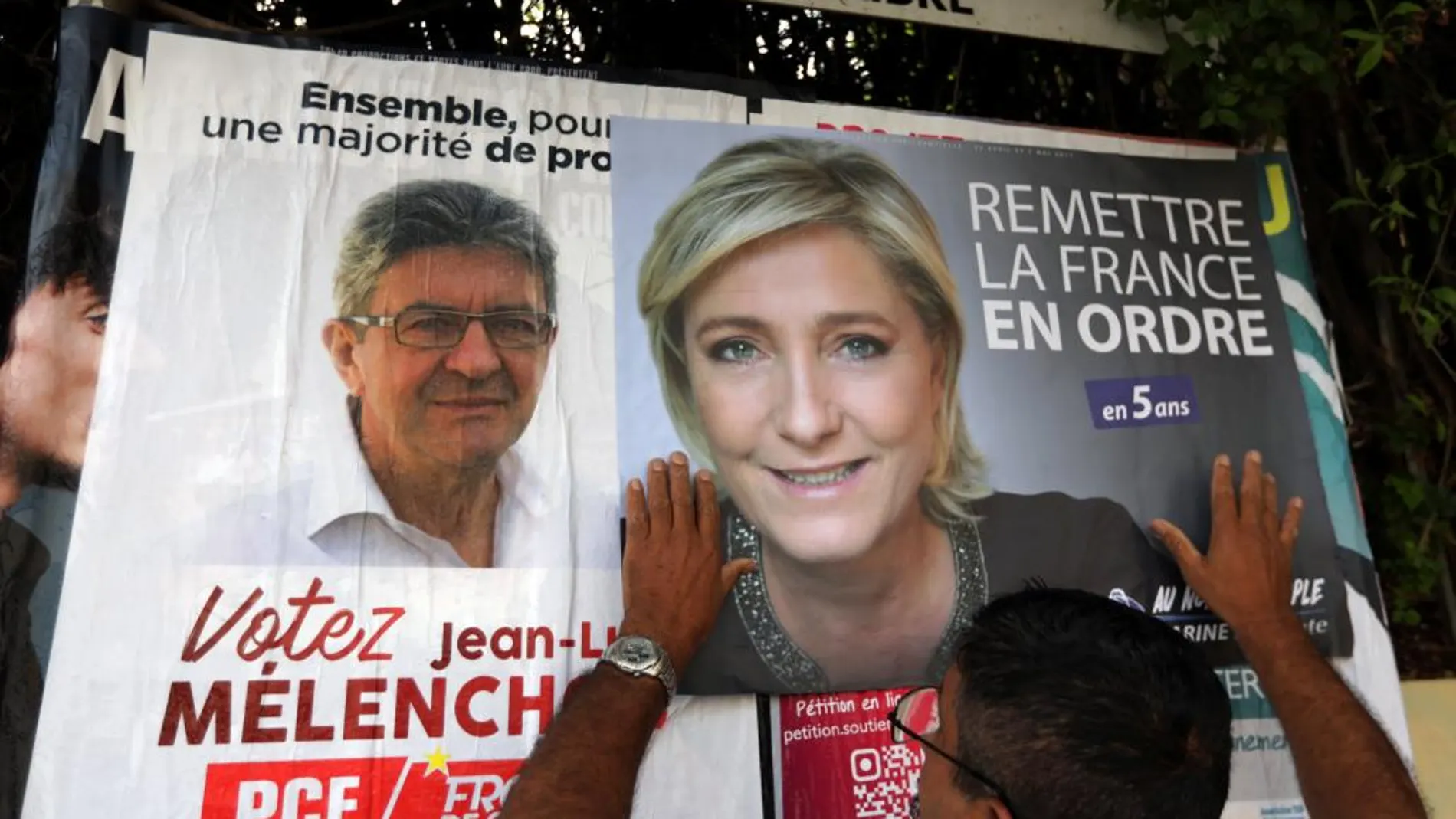 Un hombre cuelga un cartel de la candidata presidencial por el Frente Nacional, Marine Le Pen, en Antibes