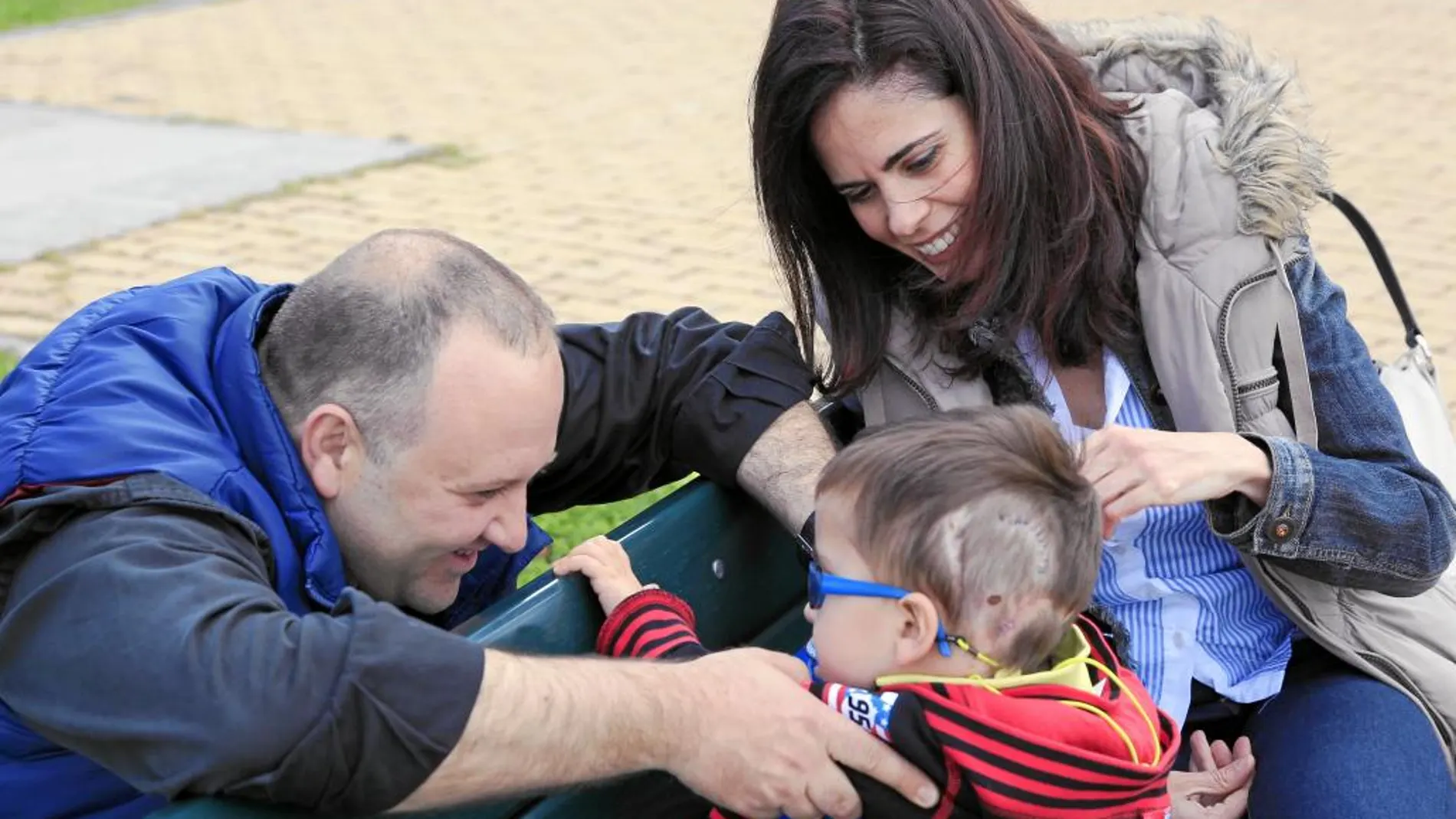 Iván, de seis años, se divierte con sus padres, Marcos y Patricia, antes de entrar a la consulta del doctor Hinojosa, del Hospital Quirón Pozuelo, que le ha conseguido quitar el 95% del tumor