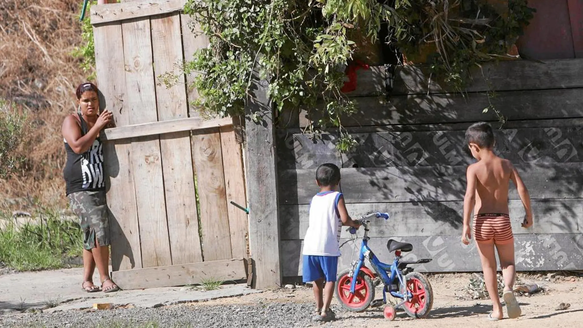 Dos niños corren por el asentamiento chabolista del Vacie, ubicado en Sevilla