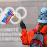 Una mujer porta una bandera rusa enfrente del edificio en el que se celebró el Comité Ejecutivo del Comité Olímpico Internacional