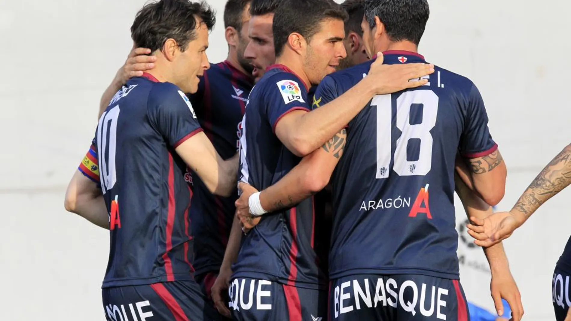 El centrocampista del Huesca Juanjo Camacho (i) celebra con sus compañeros la consecución del primer gol de su equipo