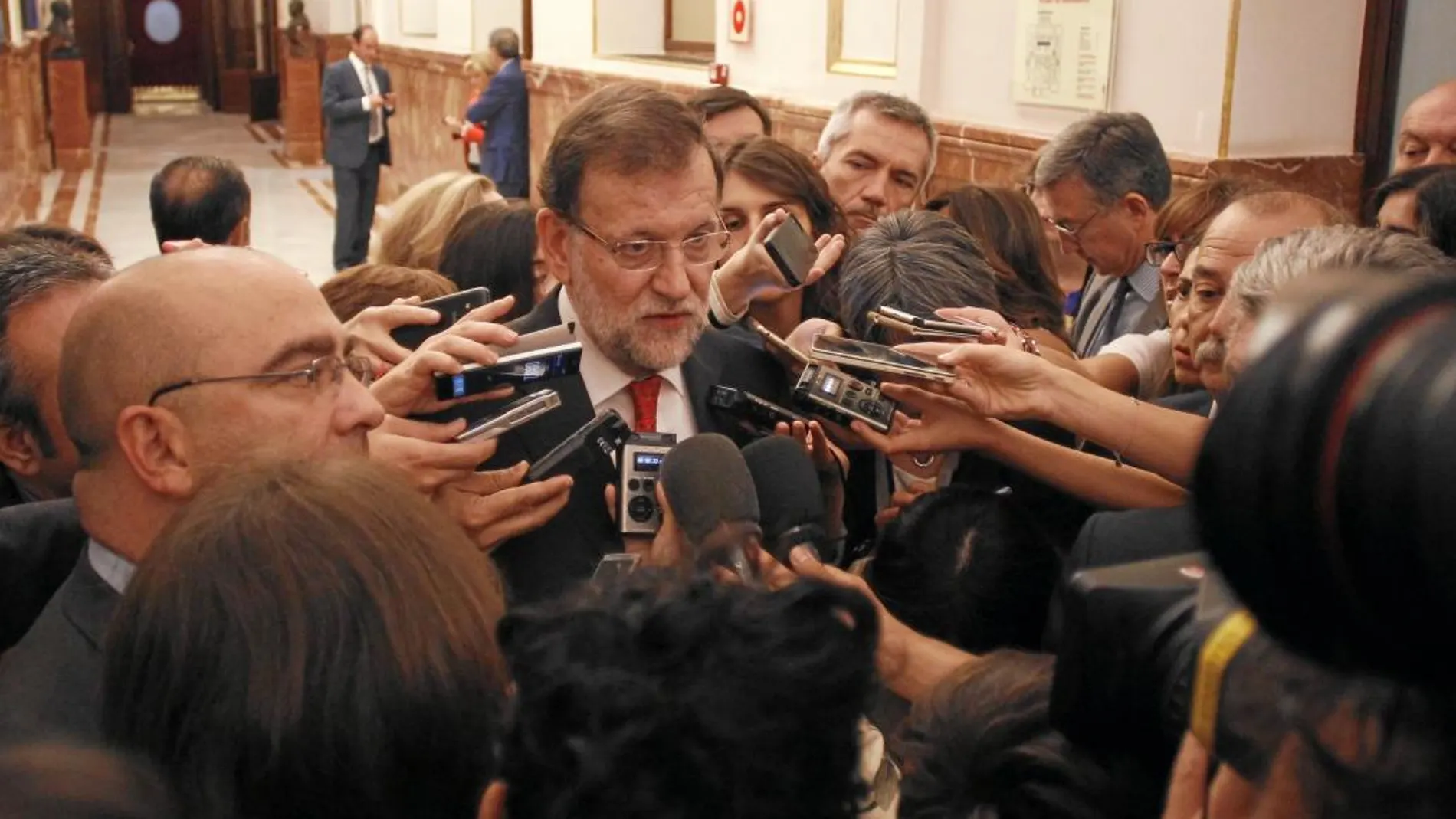 El presidente del Gobierno, Mariano Rajoy, atiende ayer a los periodistas en los pasillos del Congreso