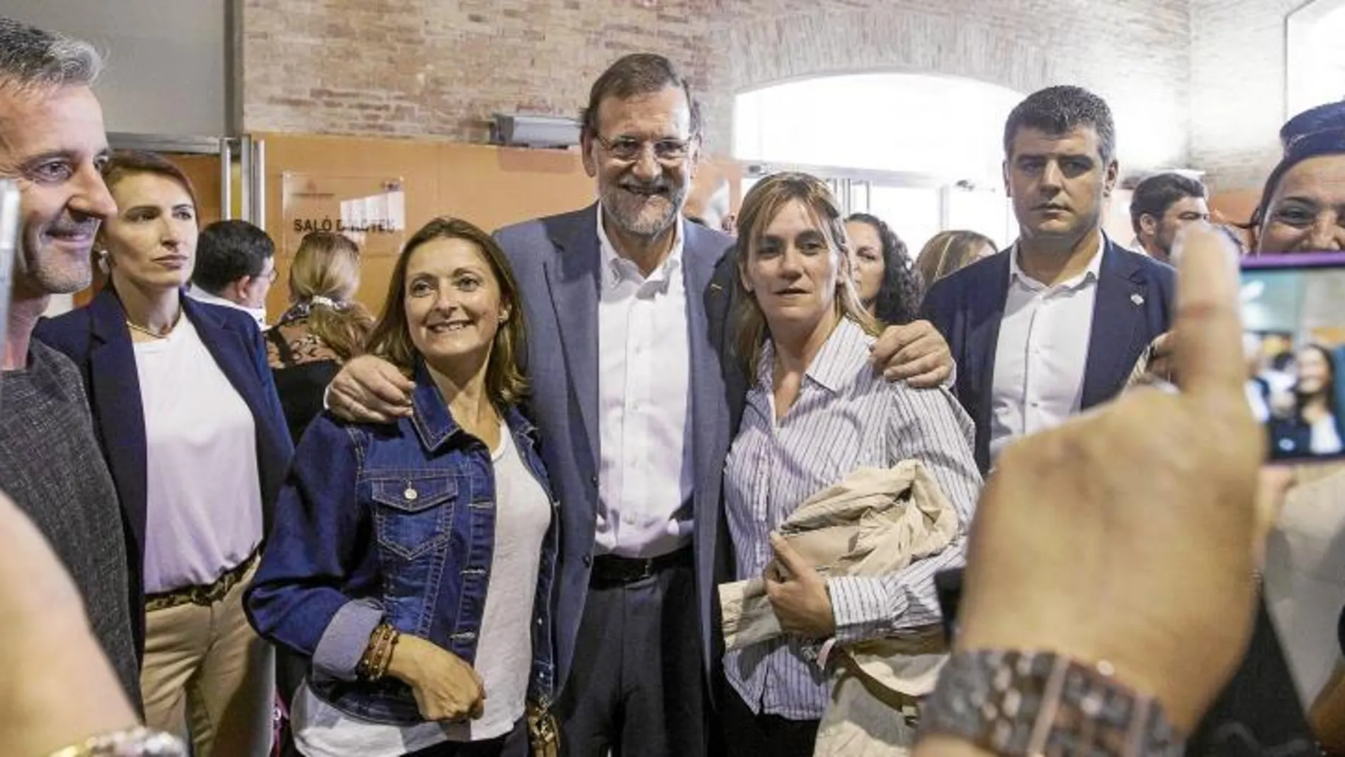 Rajoy posa con unos simpatizantes durante un acto del PP ayer en Valencia