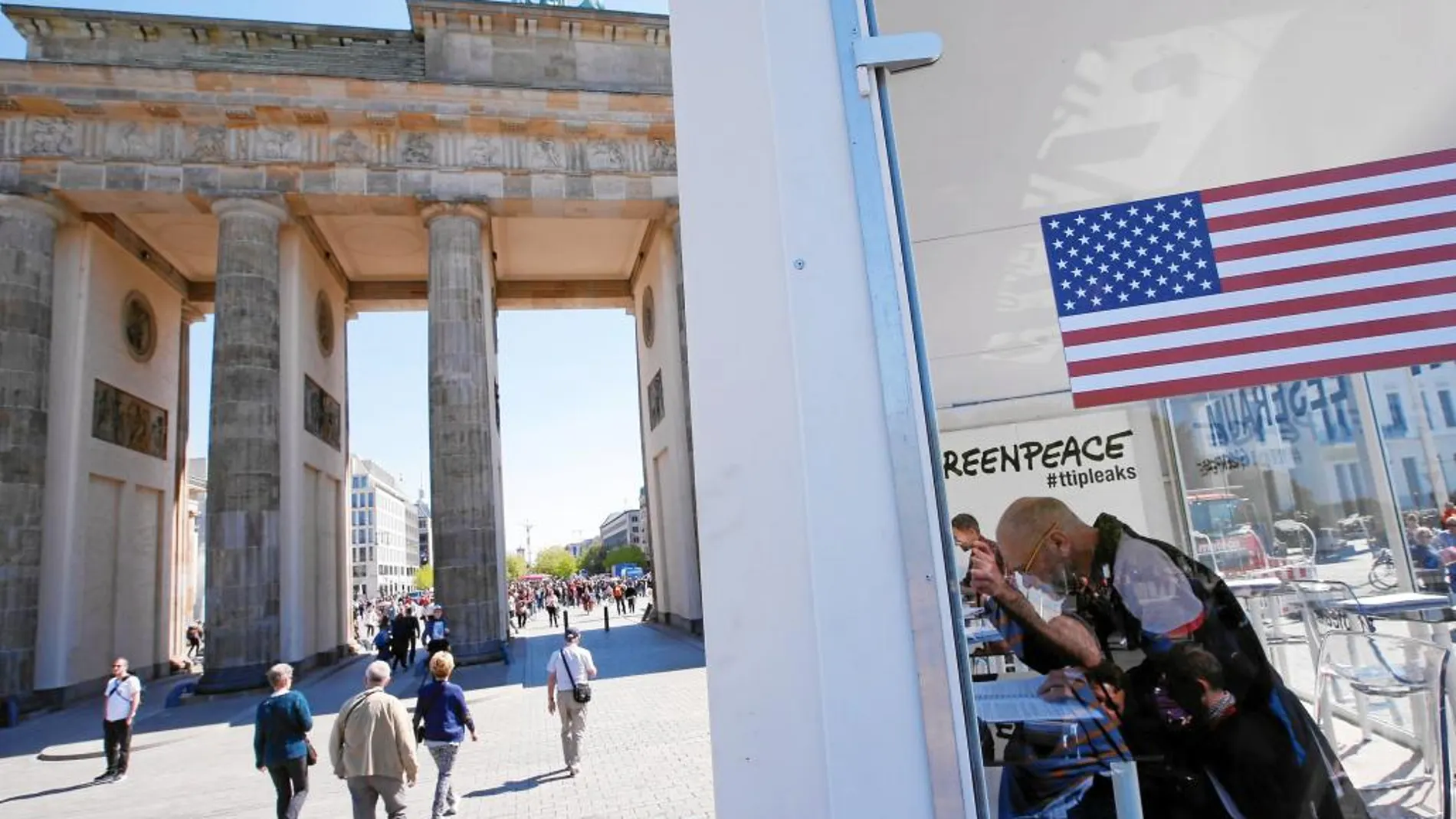 Un hombre lee los documentos filtrados del TTIP en una caseta instalada en la Puerta de Brandemburgo, en Berlín