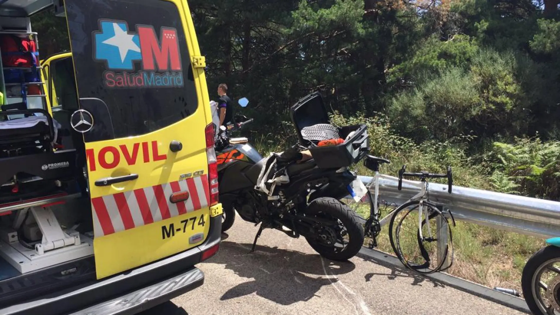 Imagen de la moto y de la bicicleta, junto a la ambulancia de Emergencias Madrid