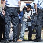 Un niño intenta evitar que su madre baje del tren para subir a un autobús en la estación de Rodby (Dinamarca)