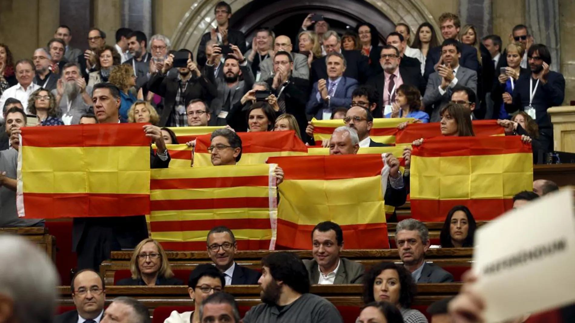 Los diputados del PP muestran banderas de España y Cataluña tras la aprobación