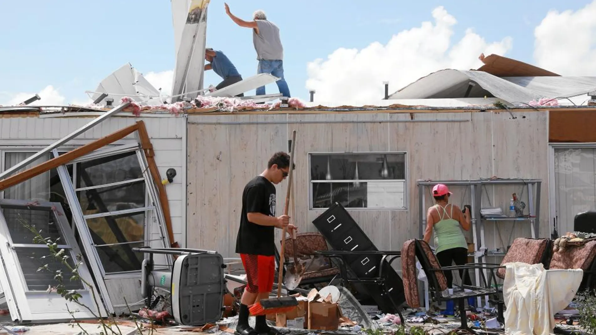 Una familia limpia su casa portátil tras los daños causados por el huracán Irma en la ciudad de Naples, en Florida