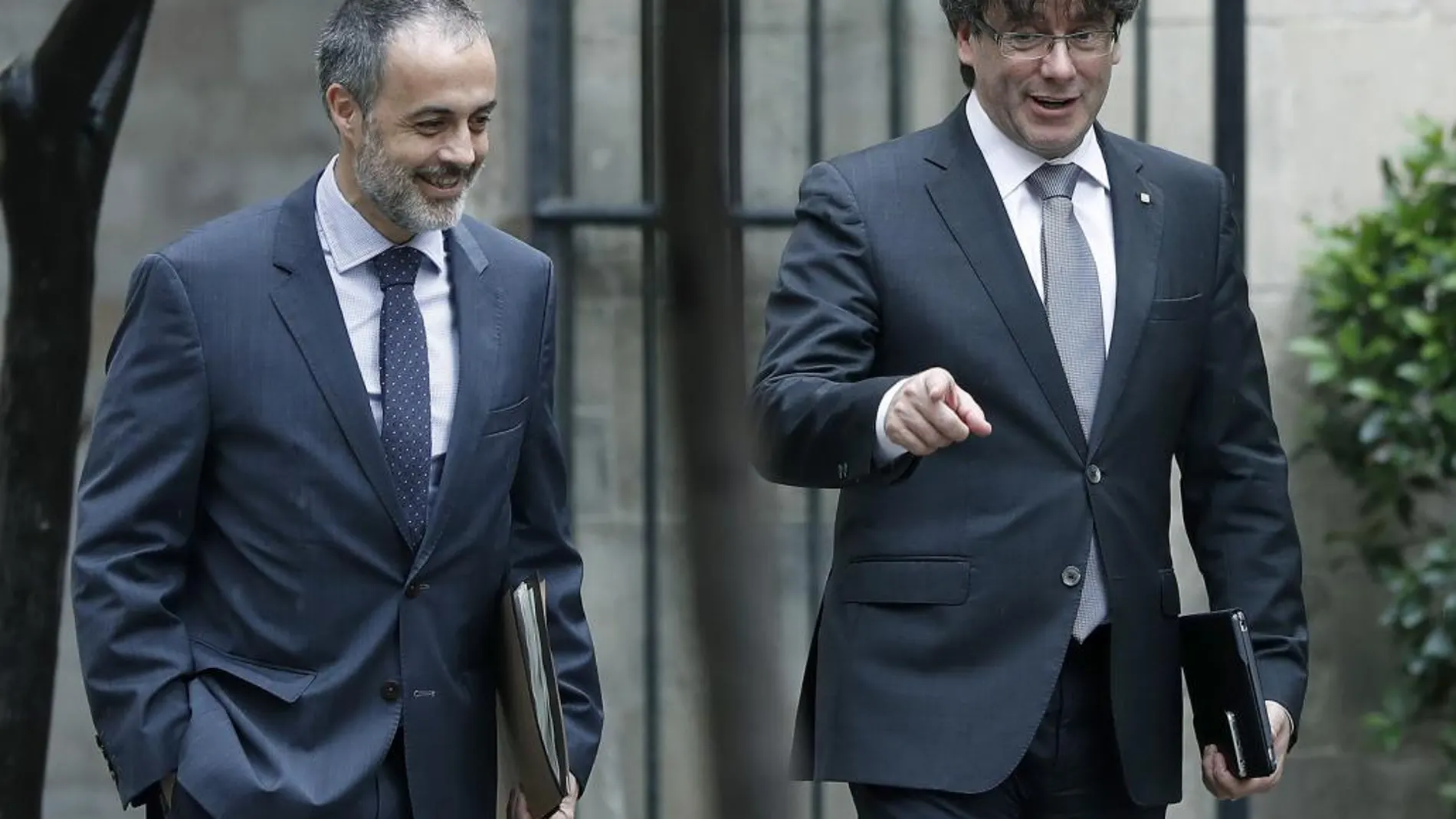 El presidente de la Generalitat, Carles Puigdemont (d), acompañado por el secretario del Govern, Joan Vidal (i).