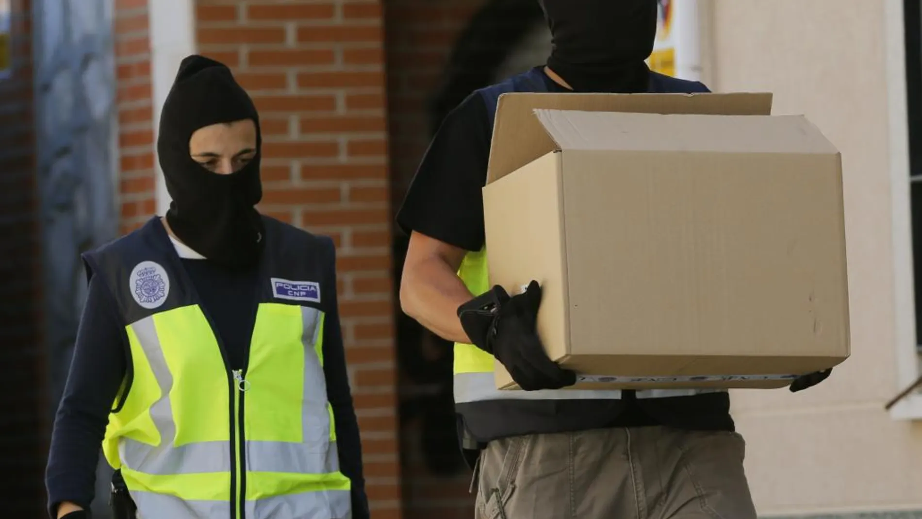 Agentes de la Policía Nacional tras concluido el registro de la casa del supuesto yihadista detenido en la localidad madrileña de San Martín de la Vega