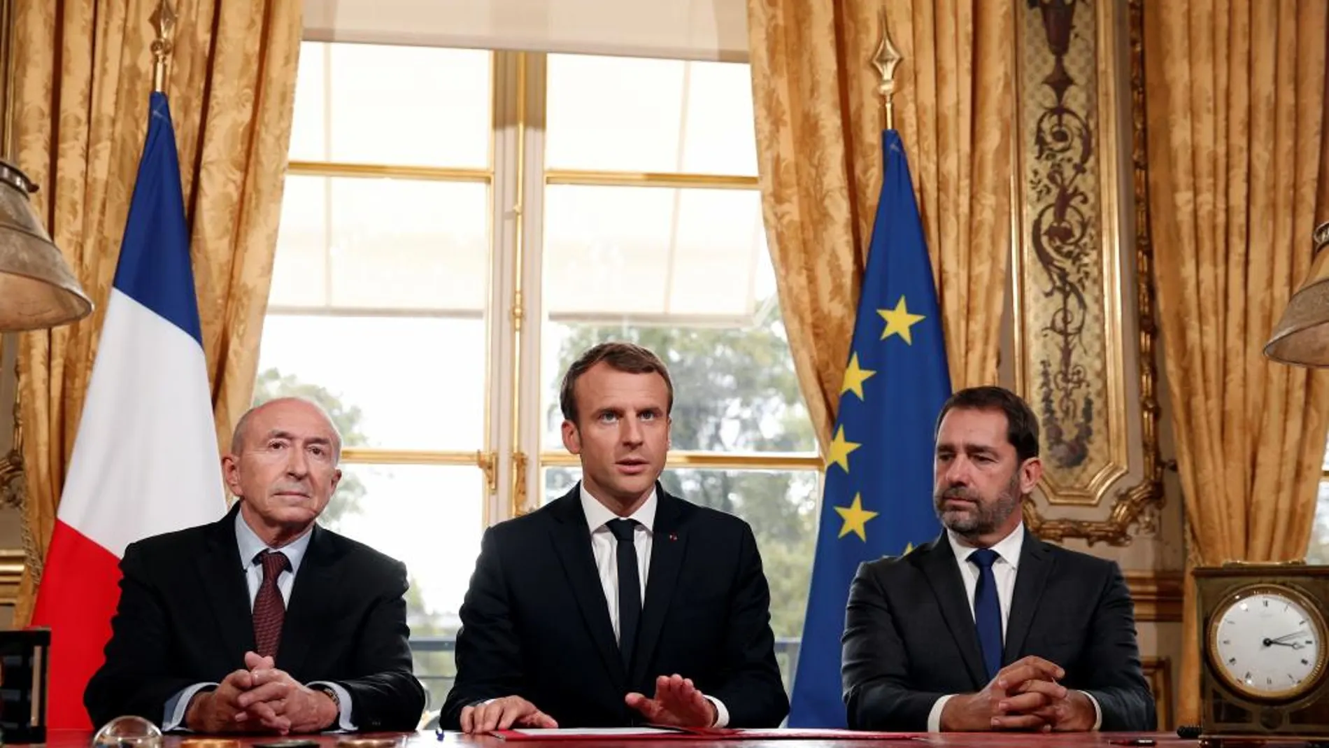 El presidente francés Emmanuel Macron atiende a los medios junto al ministro de Interior Gerard Collomb (izda), y al portavoz del Gobierno, Christophe Castaner, tras la firma de una nueva ley antiterrorista en el Palacio del Elíseo
