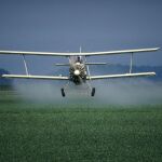 Un avión esparciendo pesticidas en un campo en Estados Unidos