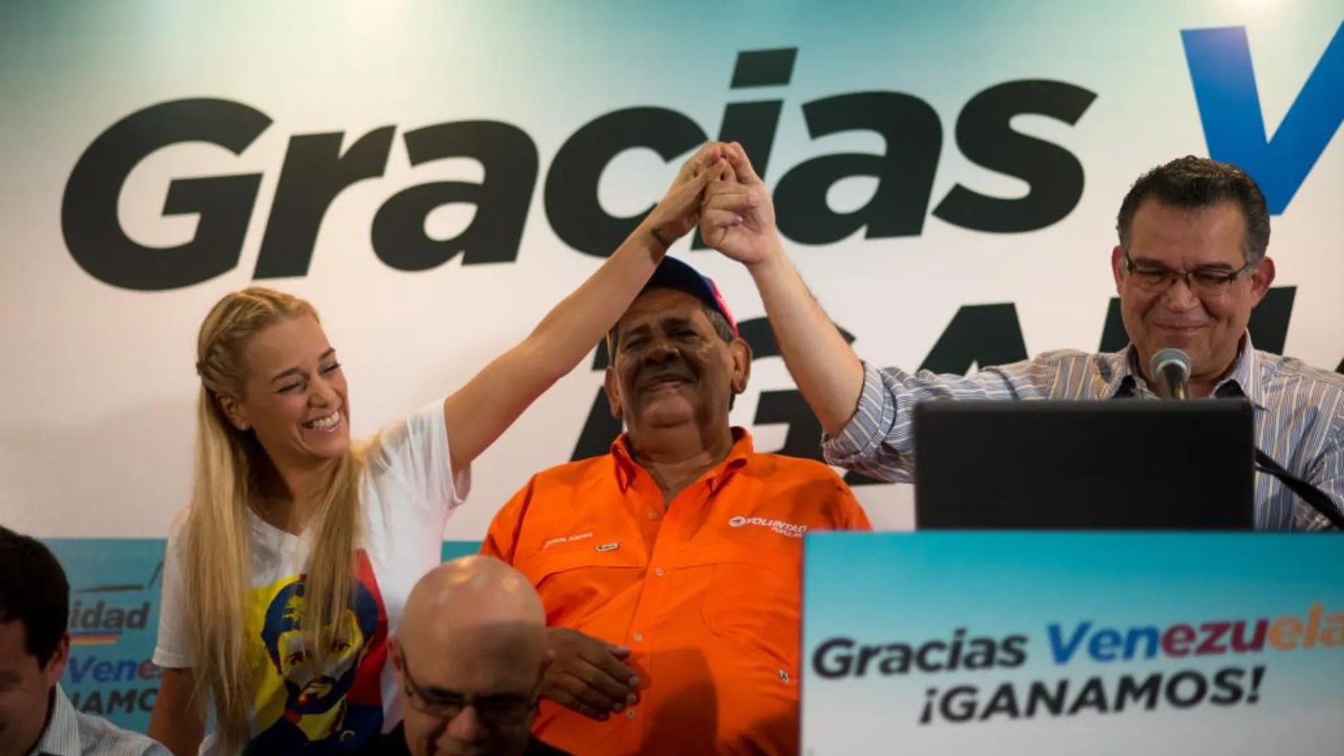 Lilian Tintori (i), esposa del líder opositor venezolano encarcelado Leopoldo López, levanta la mano de Enrique Marquez, miembro del comité ejecutivo del comando de campaña y diputado electo (d) ayer
