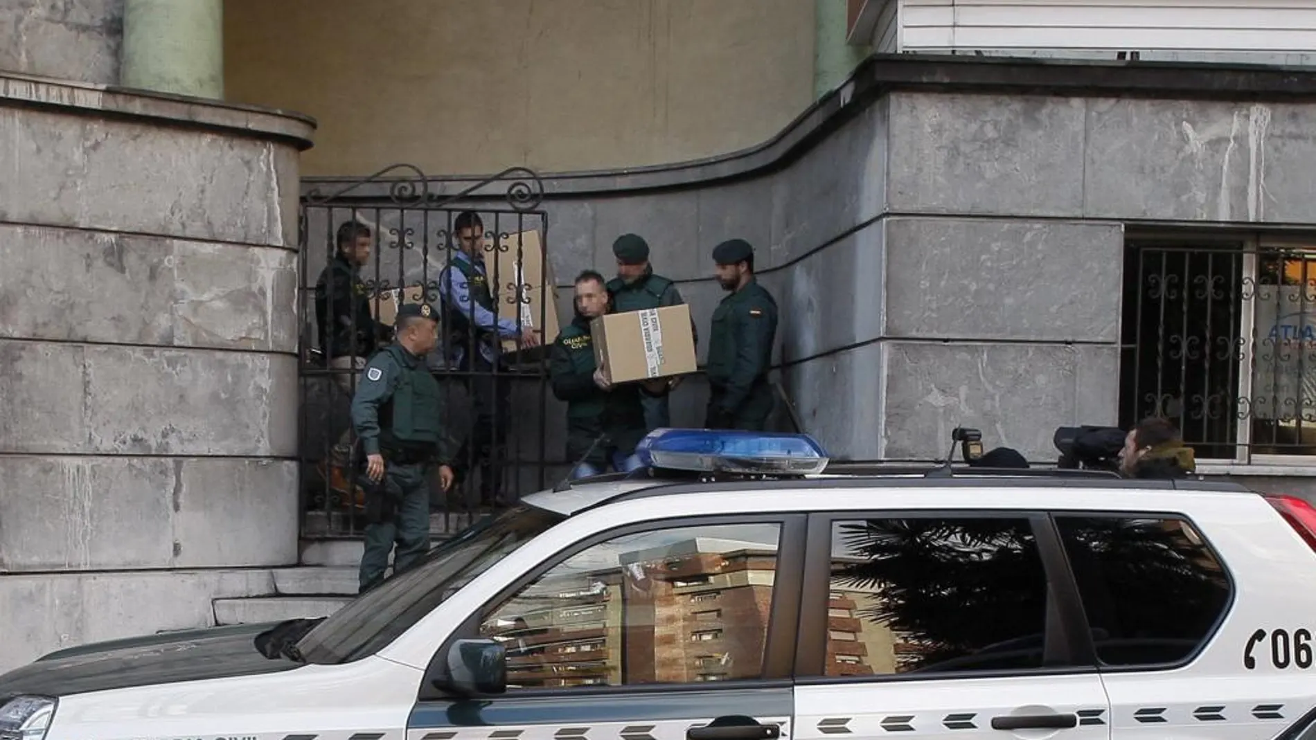 Agentes de la Unidad Central Operativa (UCO) salen con varias cajas de la sede central de UGT-Asturias en Oviedo tras finalizar el registro