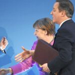 La canciller Angela Merkel y el «premier» David Cameron dan la mano al secretario general de la ONU, Ban Ki Moon
