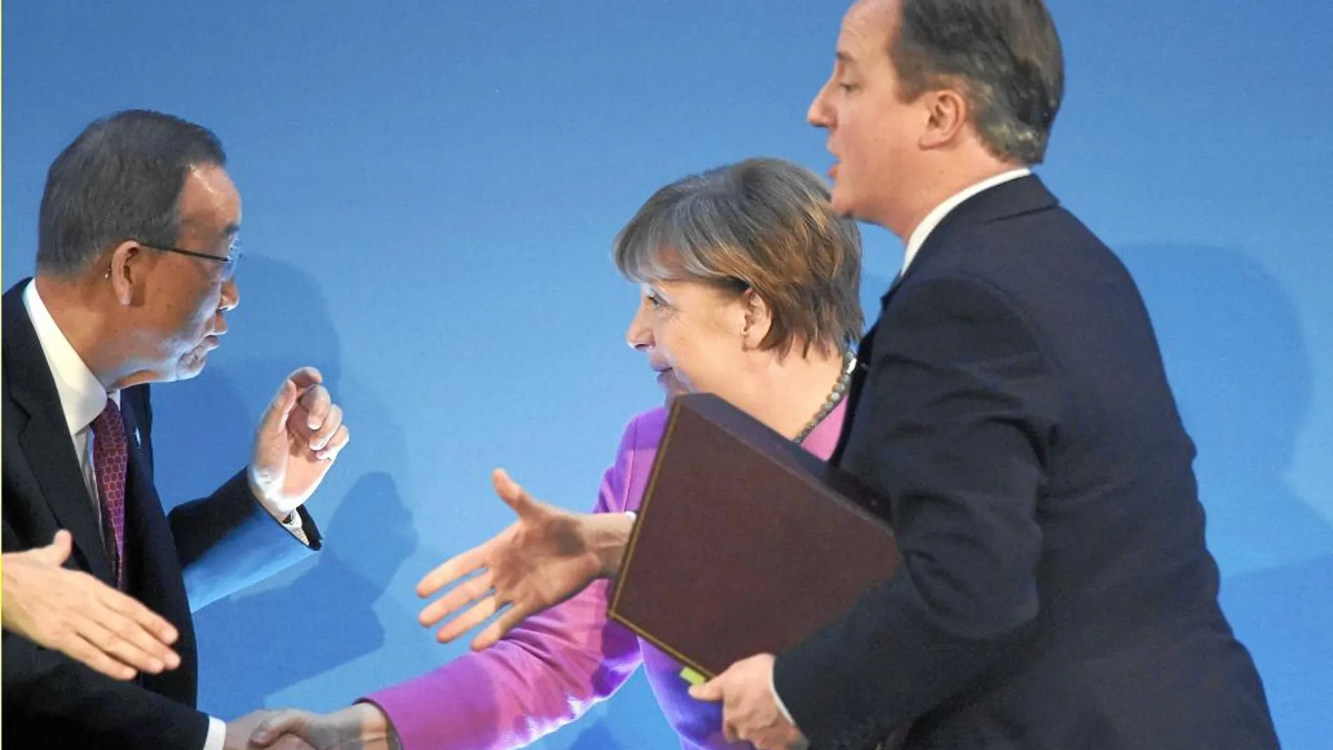 La canciller Angela Merkel y el «premier» David Cameron dan la mano al secretario general de la ONU, Ban Ki Moon