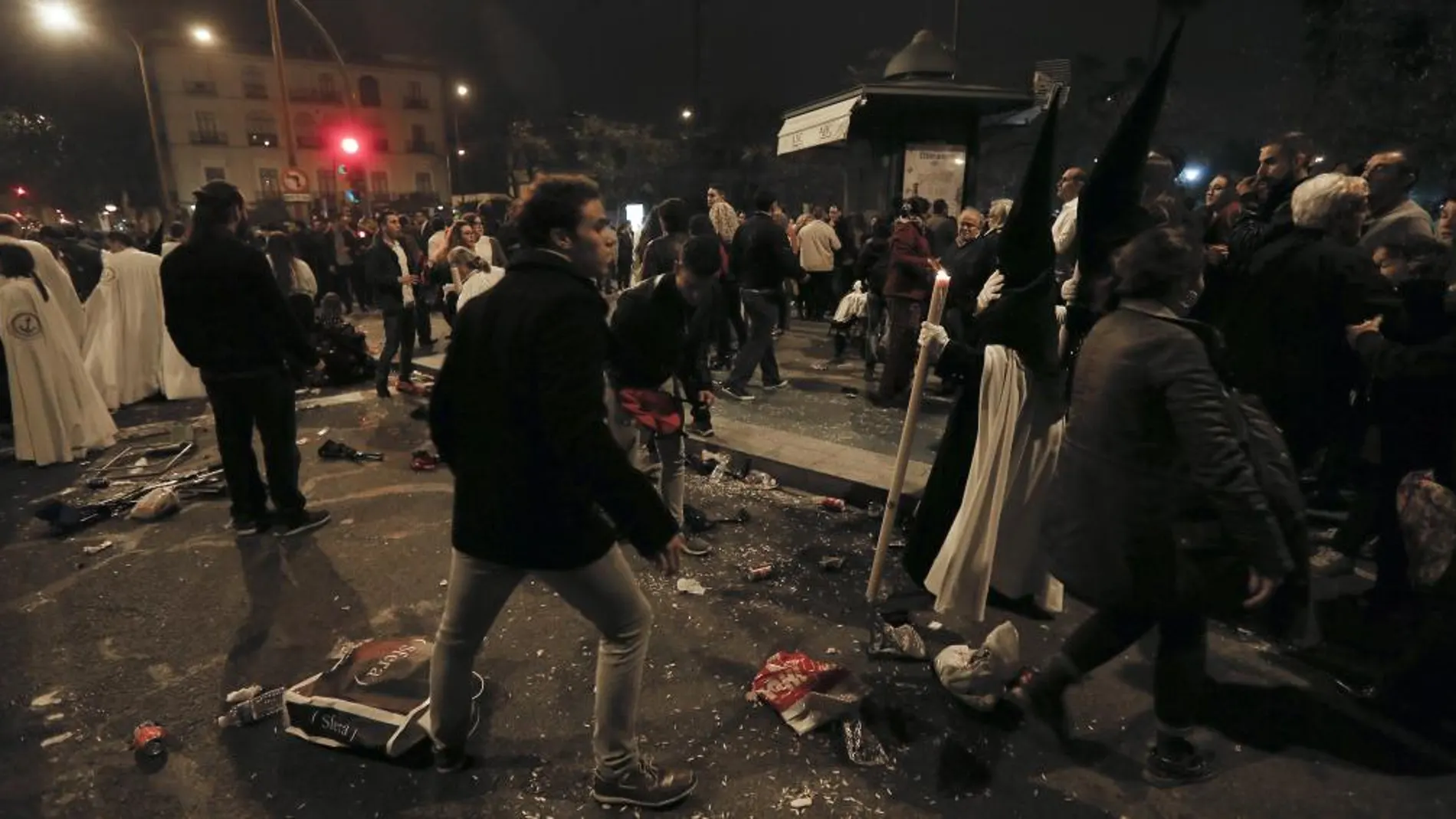 Nazarenos de La Esperanza de Triana ante el descontrol tras sufrir una estampida durante su recorrido procesional a su paso por el puente de Triana