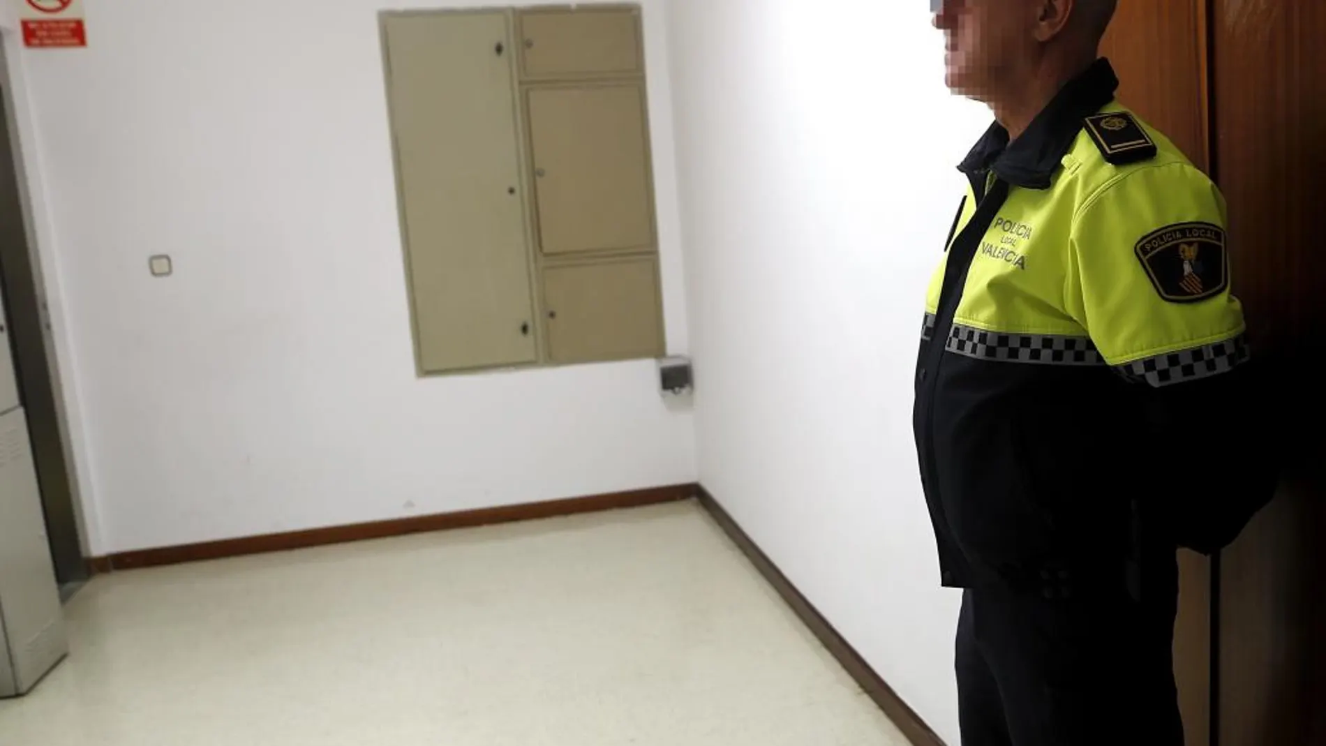 Un policía custodia la puerta del grupo popular en el Ayuntamiento de Valencia mientras agentes de la Guardia Civil registran esta mañana las dependencias.