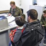 Un soldado entrega documentos a una familia de refugiados en la oficina de registro de Heidelberg (Alemania)