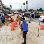 varias personas llenan sacos con arena para proteger sus propiedades ante la llegada del huracán Irma