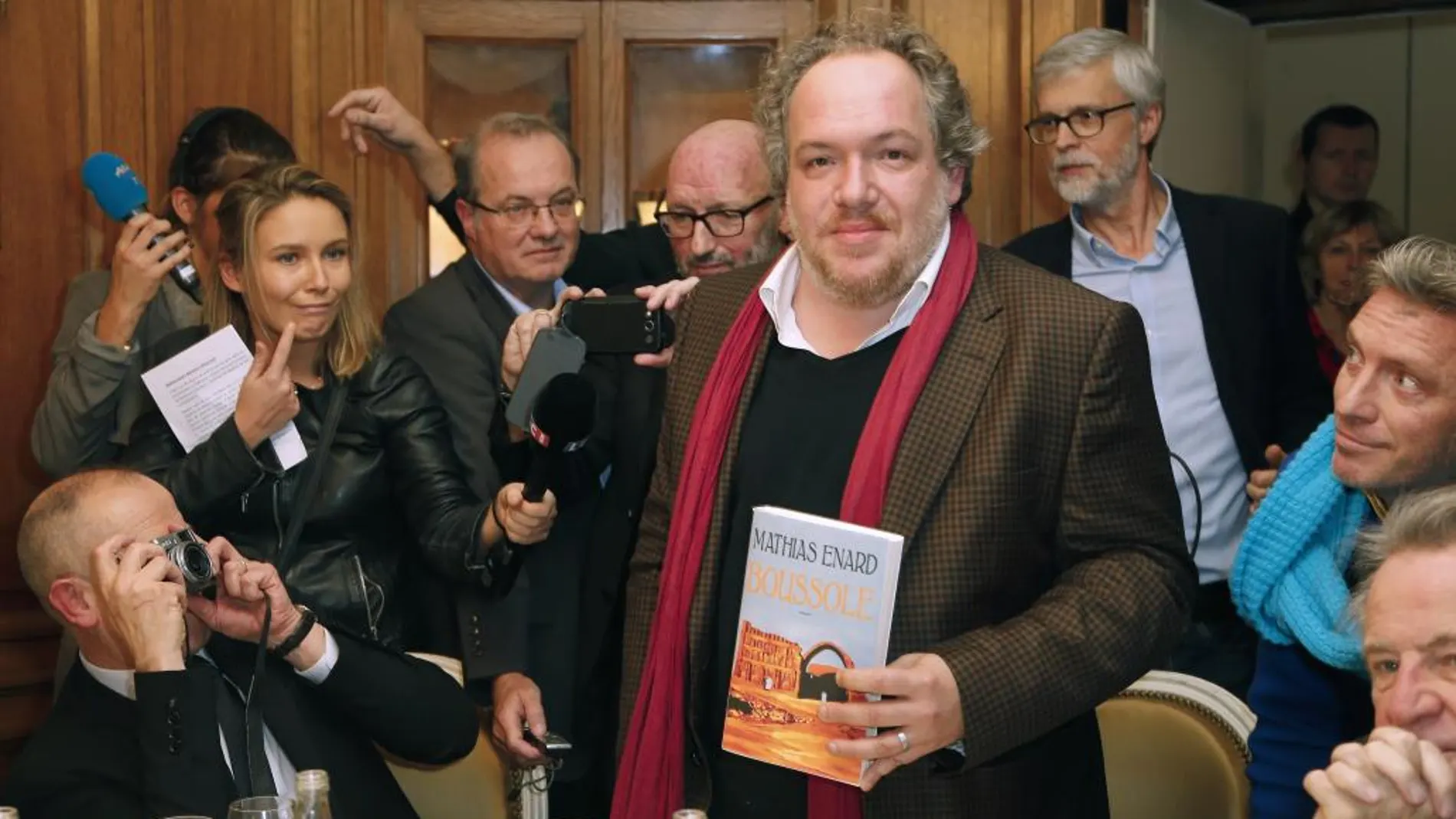 El escritor francés, Mathias Enard, posa para los fotógrafos con un ejemplar de su obra premiada, en París
