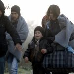 Un niño llora al caminar en el frío con su familia hacia el centro de tránsito para refugiados cerca de la ciudad macedonia Gevgelija, después de cruzar la frontera de Grecia