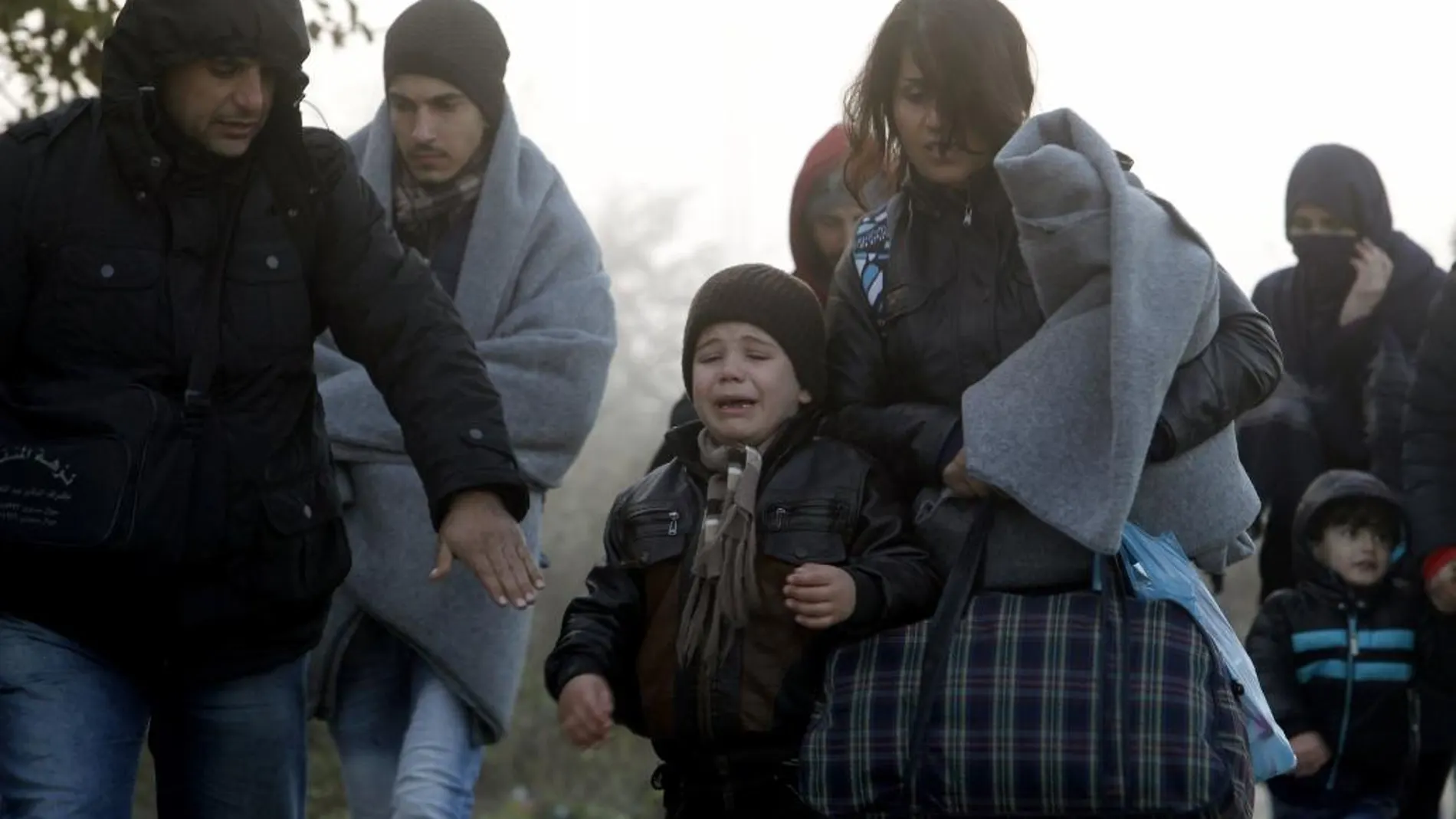 Un niño llora al caminar en el frío con su familia hacia el centro de tránsito para refugiados cerca de la ciudad macedonia Gevgelija, después de cruzar la frontera de Grecia