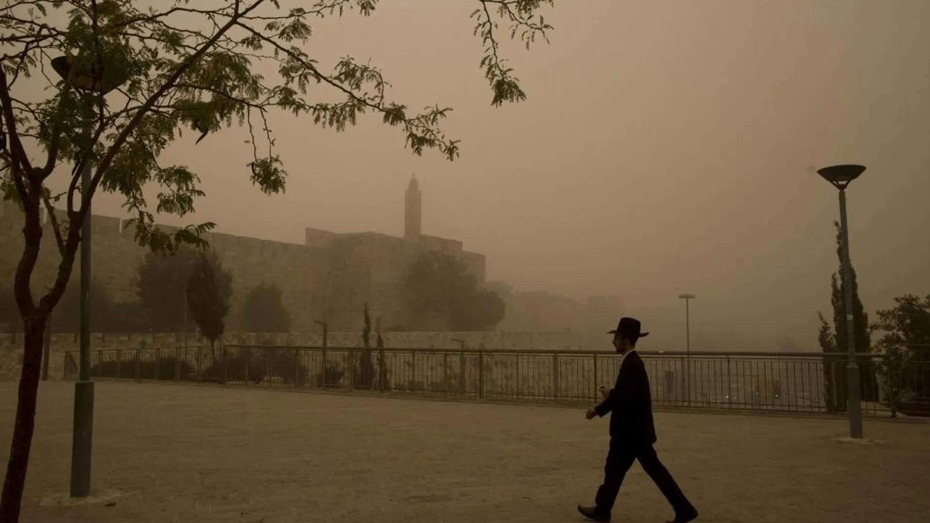 Un hombre camina por las calles de Jerusalén (Israel) durante una tormenta de arena.