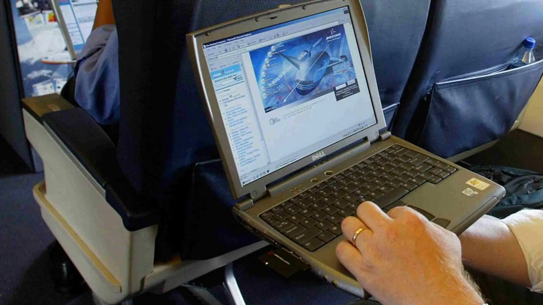 Un viajero usa un ordenador portátil en el interior de un avión.
