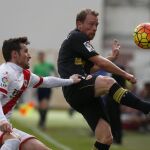 El centrocampista danés del Sevilla, Michael Krohn-Dehli (d), controla la pelota ante la oposición del defensa del Rayo Vallecano, Roberto Román "Tito".