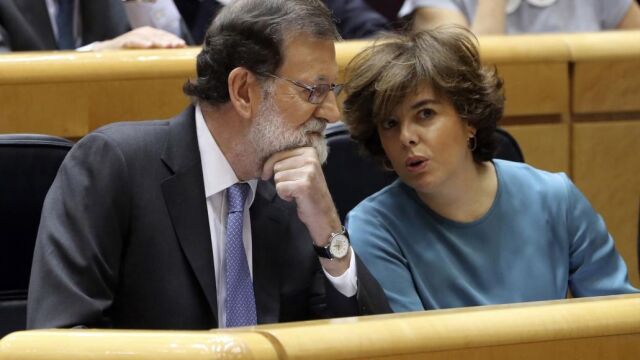 El presidente del Gobierno, Mariano Rajoy (i), conversa con la vicepresidenta, Soraya Sáenz de Santamaría (d), al inicio del pleno extraordinario del Senado