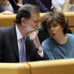 El presidente del Gobierno, Mariano Rajoy (i), conversa con la vicepresidenta, Soraya Sáenz de Santamaría (d), al inicio del pleno extraordinario del Senado