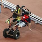 Un cámara de televisión choca contra el atleta jamaicano Usain Bolt