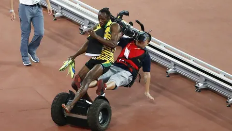 Un cámara de televisión choca contra el atleta jamaicano Usain Bolt