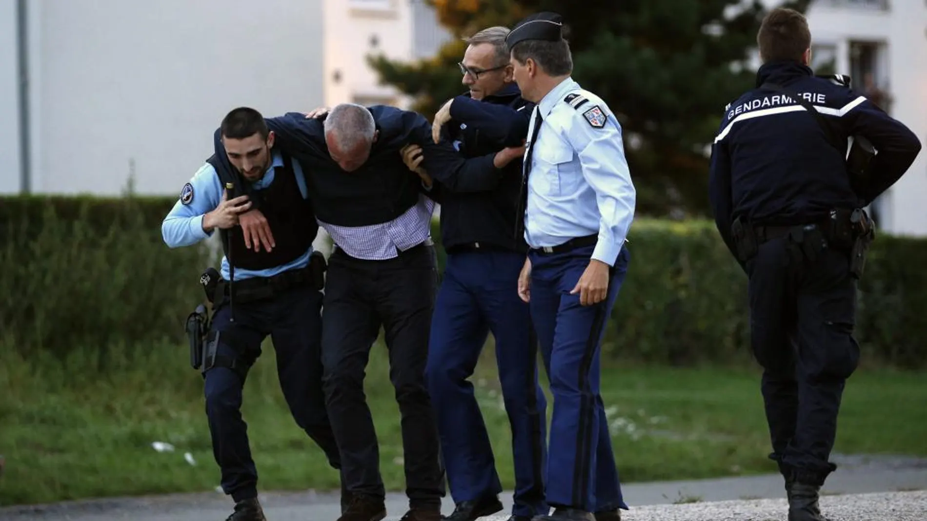 Oficiales de Policía ayudan a un periodista sin identifcar tras ser agredido por romaníes cerca a un campamento nómada donde se registró un tiroteo