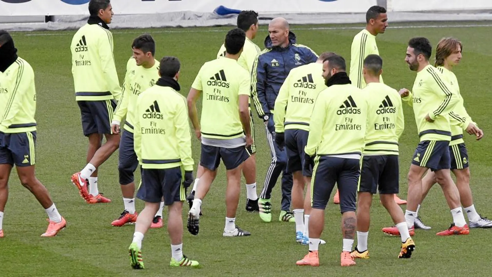 Los futbolistas del Madrid rodean a su técnico durante el entrenamiento de ayer