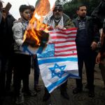 Un palestino quema una bandera de EE UU y una imagen de Trump