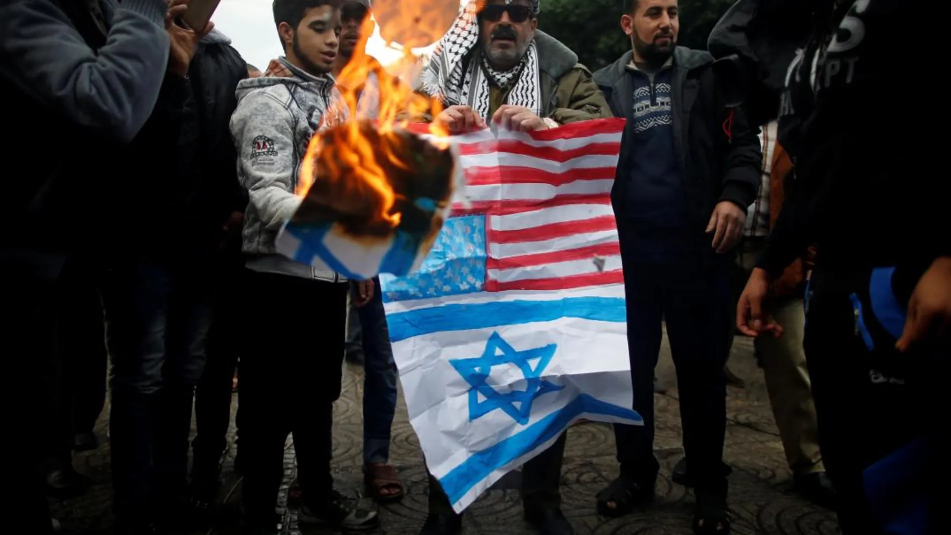 Un palestino quema una bandera de EE UU y una imagen de Trump