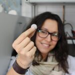 La investigadora Noelia Moreno muestra la pila experimental de litio y azufre. Fuente: UCO.